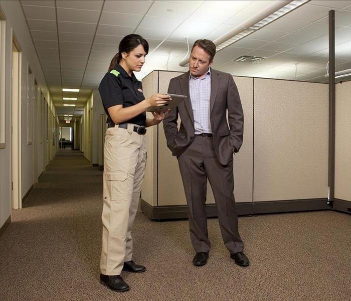 SERVPRO technician and man talking in an office